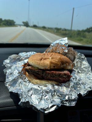 Sliced brisket sandwich and an open Texas country road