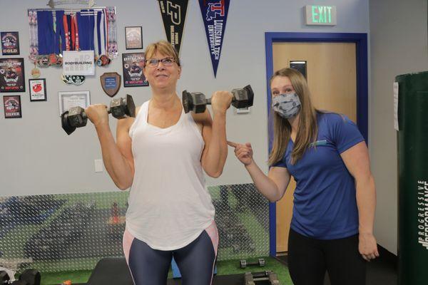 Diane showing off her guns and coach Ellen giving her encouragement