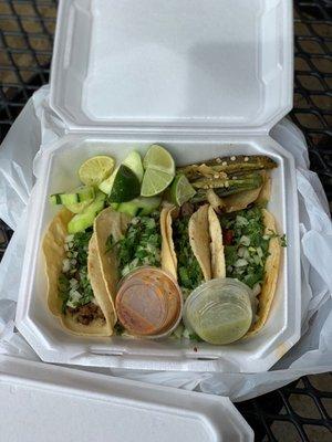 Carne asada, lengua, and barbacoa tacos with green and red salsa