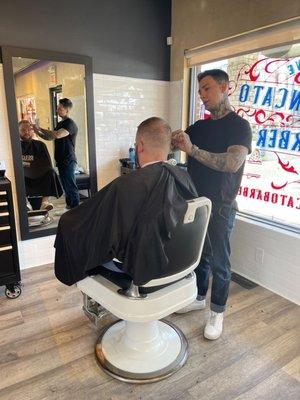 Barber Andrew finishing up a haircut.