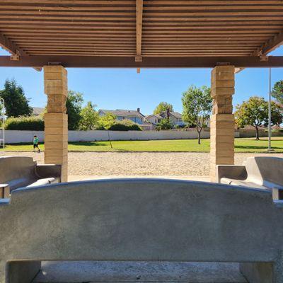 Gazebo provides shaded seating with concrete park benches.