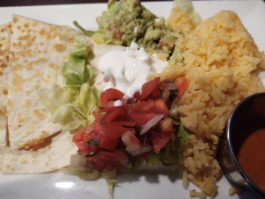 Vegetarian quesadilla with guac, sour cream, lettuce, salsa, rice and a spicy sauce.