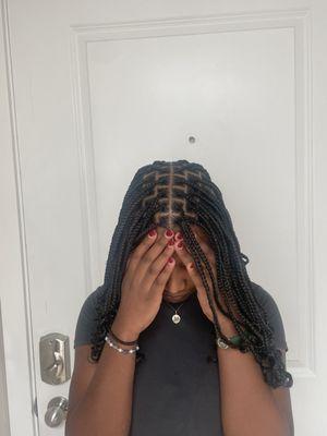 Medium shoulder length knotless braids with a middle part.