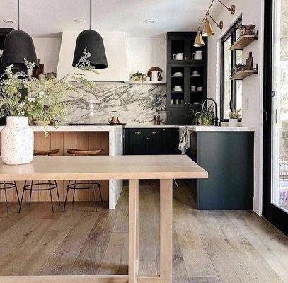 Our stunning kitchen boasts black cabinets, quartz countertops, and a sleek hardwood floor, creating a space where style meets functionality