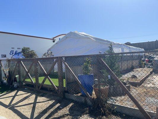 Trash piled in the back (right side of photo) and trash on the patio stuck in the fence (left side)