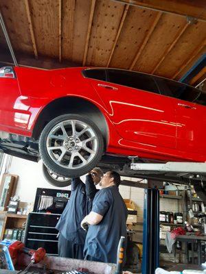 Wes and Joe discussing the rear suspension of a vehicle.