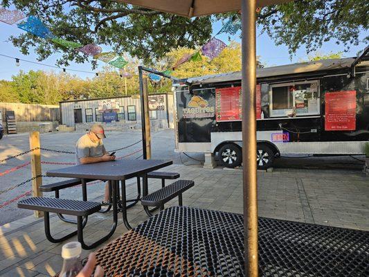 The taco stand shares the same space as a Tile shop.