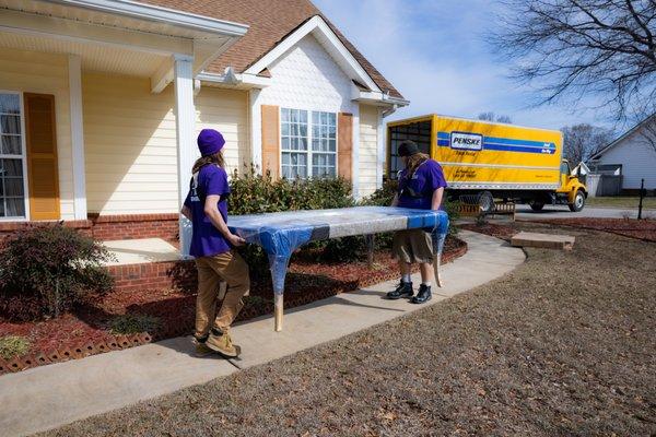 Carrying a table to the truck.