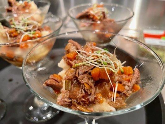 Beer braised beef short ribs on roasted garlic mashed potatoes in martini glass