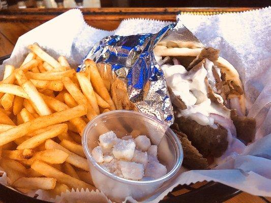 Lamb Gyro with tomato, onions, tzatziki sauce and feta cheese on the side.