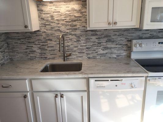 Kitchen renovation: stone backsplash, granite countertops, and new cabinetry