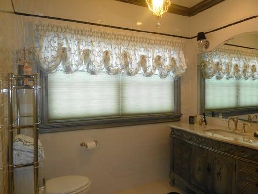 Silver, White Modern design designer fabric was used as a balloon valance. Top Down Bottom Up shades. Handpainted grey vanity.