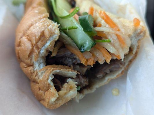 Grilled pork banh mi. Good flavors. Fresh toppings. But the bread isn't authentic crisp French bread, and the pork is wet, making it soggy.