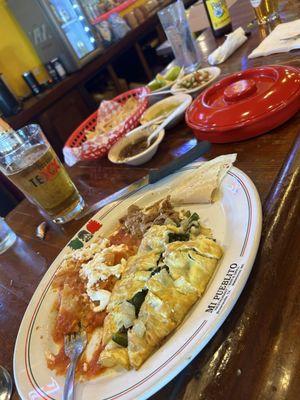 The Ranchero was a fluffy omelet filled with melted cheese, poblano pepper strips, and onions served with Chilaquiles and refried beans.