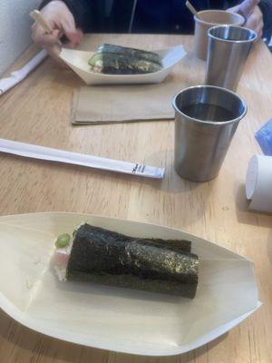 Negi hamachi temaki(fromt) vs blue crab sunomono temaki. Water cups.