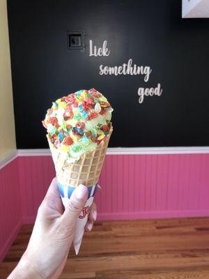 Green tea ice cream with fruity pebbles on a waffle cone