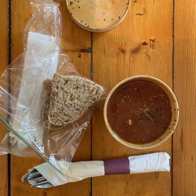 Divine tomato soup served with bread chunks, inside tables