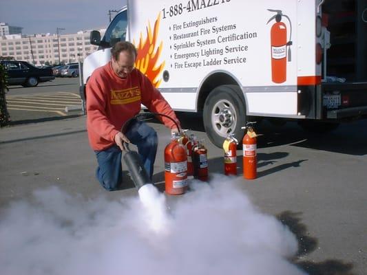 Mazzy's Fire Protection employee servicing a fire extinguisher