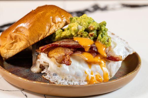 burger with bacon, cheese, guac and fried egg