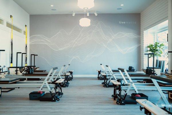 Unique design elements such as feature wall of a brain wave of someone doing Pilates accent the studio.