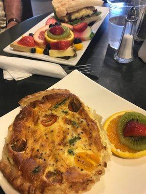 Breakfast BLT SANDWICH w/fresh fruit masterpiece on the side  (top) . Asparagus &tomato & Gouda cheese personal pie quiche