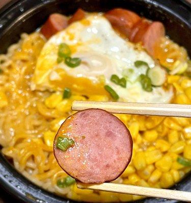 Korean Street Ramen A fried egg, corn and pork sausage over noodles and broth - pork sausage close up