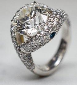 Elliott Shelton's custom diamond engagement ring featuring blue sapphires on either side all pave by hand