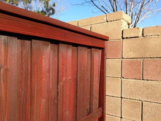 This old section of fence had been stained twice before. Again, they applied two coats of stain. See how they avoided overspray on the wall?