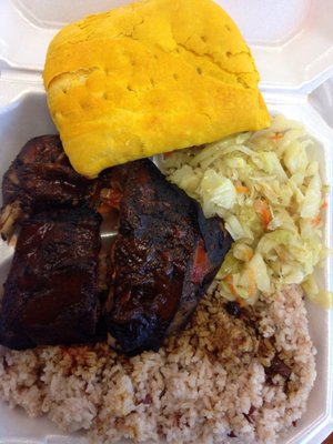 Jerk chicken, rice, cabbage, and beef patty