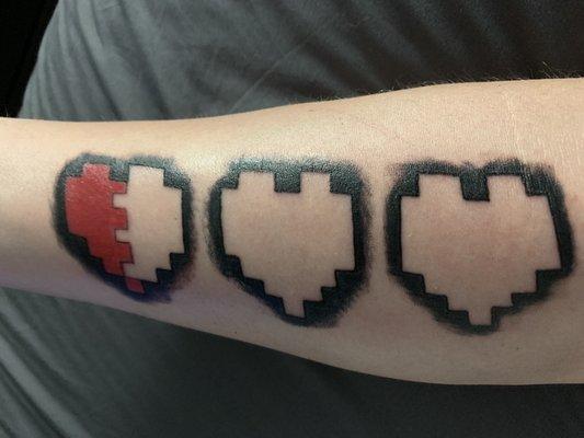 Forearm tattoo of the three starting hearts from the NES game The Legend of Zelda