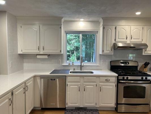 New counters and tile backsplash up the wall and over the window.