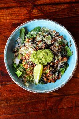 Tender pulled pork, grilled onion, diced tomato, black beans and guacamole; tossed with charred jalapeño salsa and topped with cotija cheese