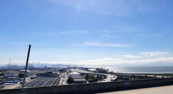 View from the I-880 flyover ramp, looking towards the Oakland side of the Bay Bridge. San Francisco skyline is in the far distance.