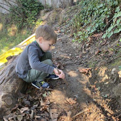 Experiencing the natural world and experimenting with his surroundings in the play yard