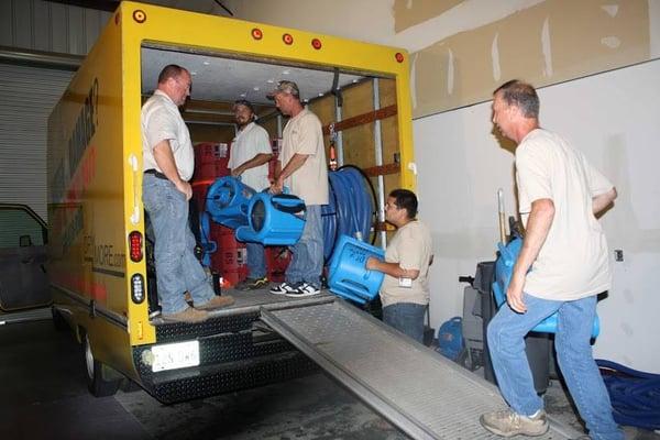 DryMoreemergency water damage clean up technicians loading the work  truck