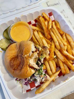 Hot chicken sandwich with fries and pickles