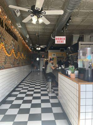 Inside of restaurant seating. Beautiful sign on the left!