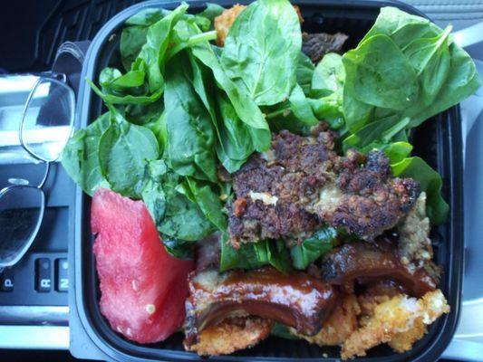 My to-go box, 3 or 4 steaks, a couple chicken livers, a lot of spinach, half a dozen shrimpl, some raisins and a piece of watermelon.