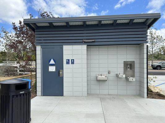 Solo bathroom with sink, soap dispenser, hand dryer, drinking fountain, & water bottle refill station.