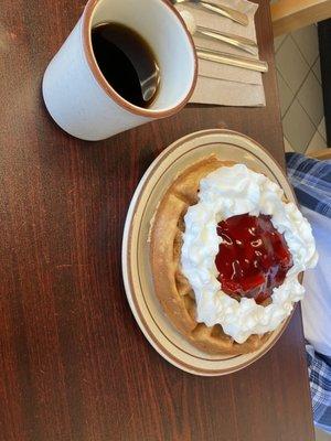 Waffle with strawberries and whipped cream.