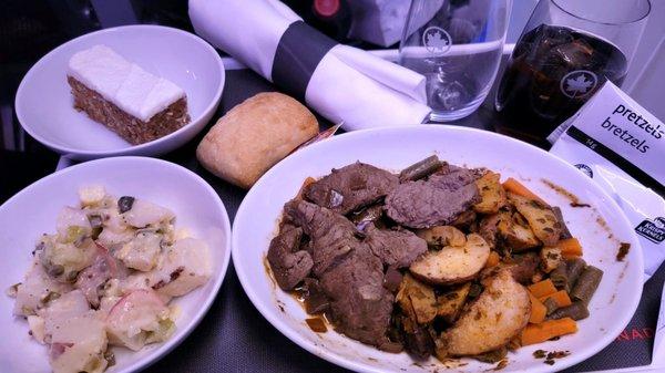 Dinner: potato salad, braised beef with potatoes and vegetables, dinner roll and carrot cake