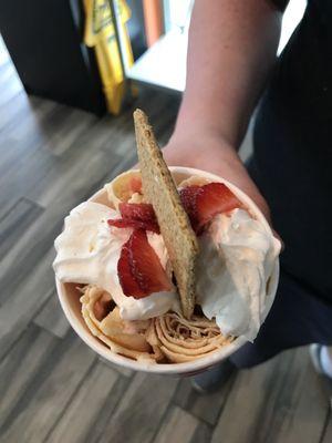 Strawberry cheesecake with whipped cream, strawberries, and graham cracker