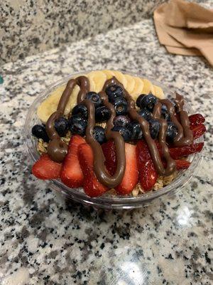 My boyfriend's small açaí bowl with fruit, granola, Nutella and honey.