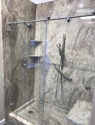 Gorgeous Valencia Granite shower system with modern barn style glass doors, and brushed nickel fixtures.