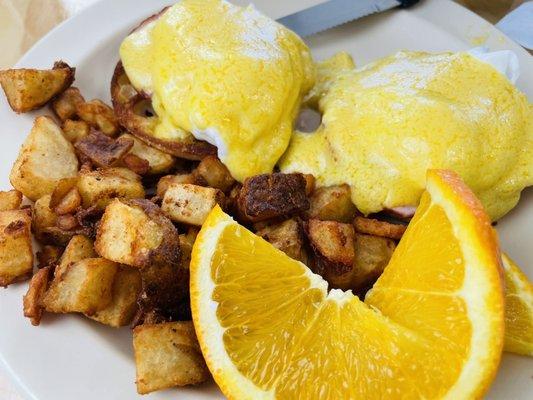 Eggs Benedict with crispy home fries.