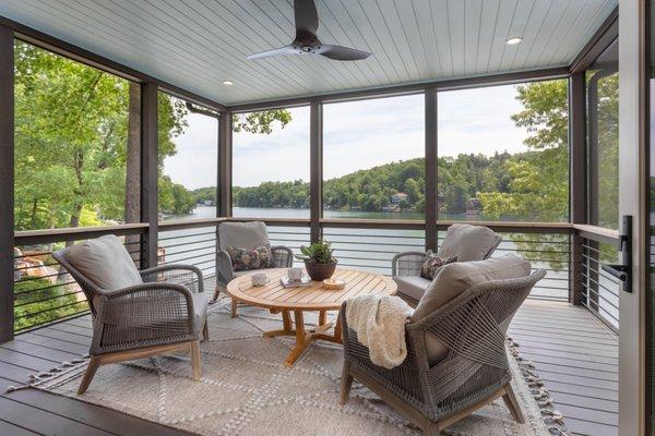 Screened Porch at Lake Lure, NC featuring woven outdoor chairs and a chat height teak cocktail table.