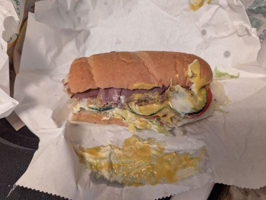 A sandwich that had mustard poured on it.