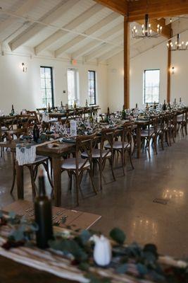 Reception space.  Eucalyptus is HCD Weddings/Premier package. Wine bottle lanterns/Table Names are DIY. Linens are from Amazon.