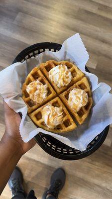 Sweet potato waffle featuring whip cream and caramel drizzle.