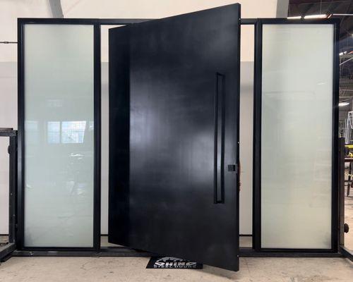 Modern security door made of steel, painted in blackened steel, with triple pane privacy glass.